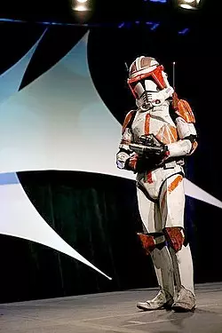 Homme portant une armure blanche et orange.