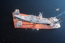 L'objet du casus-belli de la bataille des plates-formes pétrolières Sassan et Sirri de 1988, la frégate USS <em>Samuel B Roberts</em> en cours de rapatriement à bord du navire semi-submersible Mighty Servant 2 après avoir été touché par une mine iranienne.