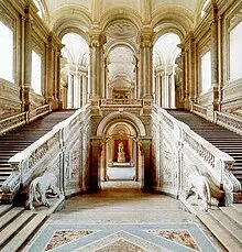 Photo d'un grand double escalier à l'intérieur d'un palais richement décorée.