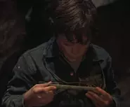 Mikey examinant le médaillon de cuivre