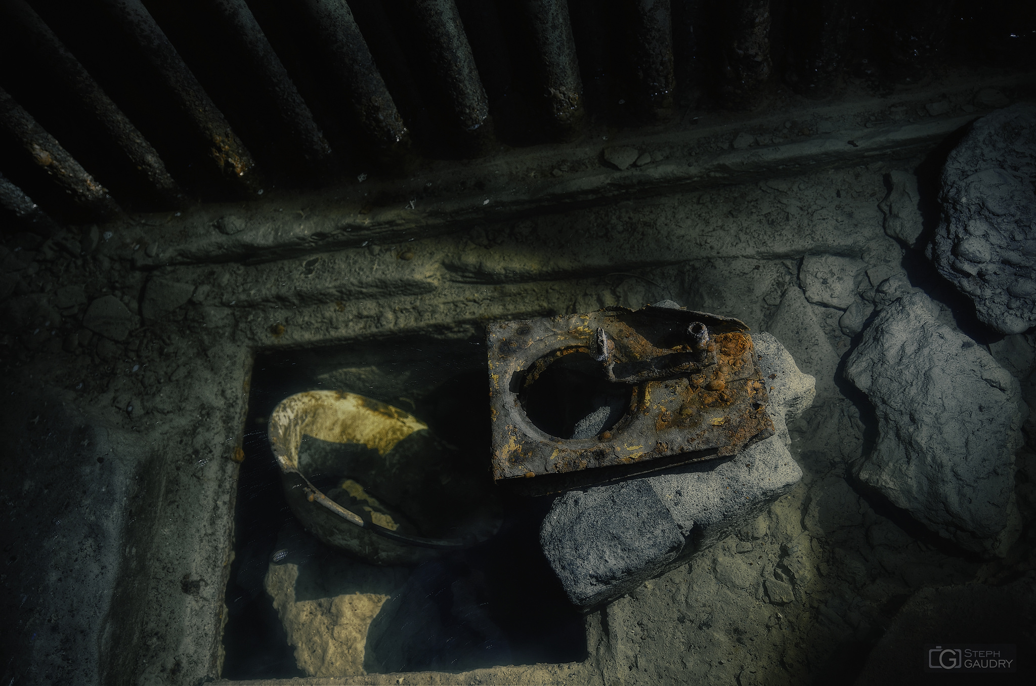 Vaisselle et matériel abandonné sous l'eau du tunnel vers le coffre de tête. [Cliquez pour lancer le diaporama]