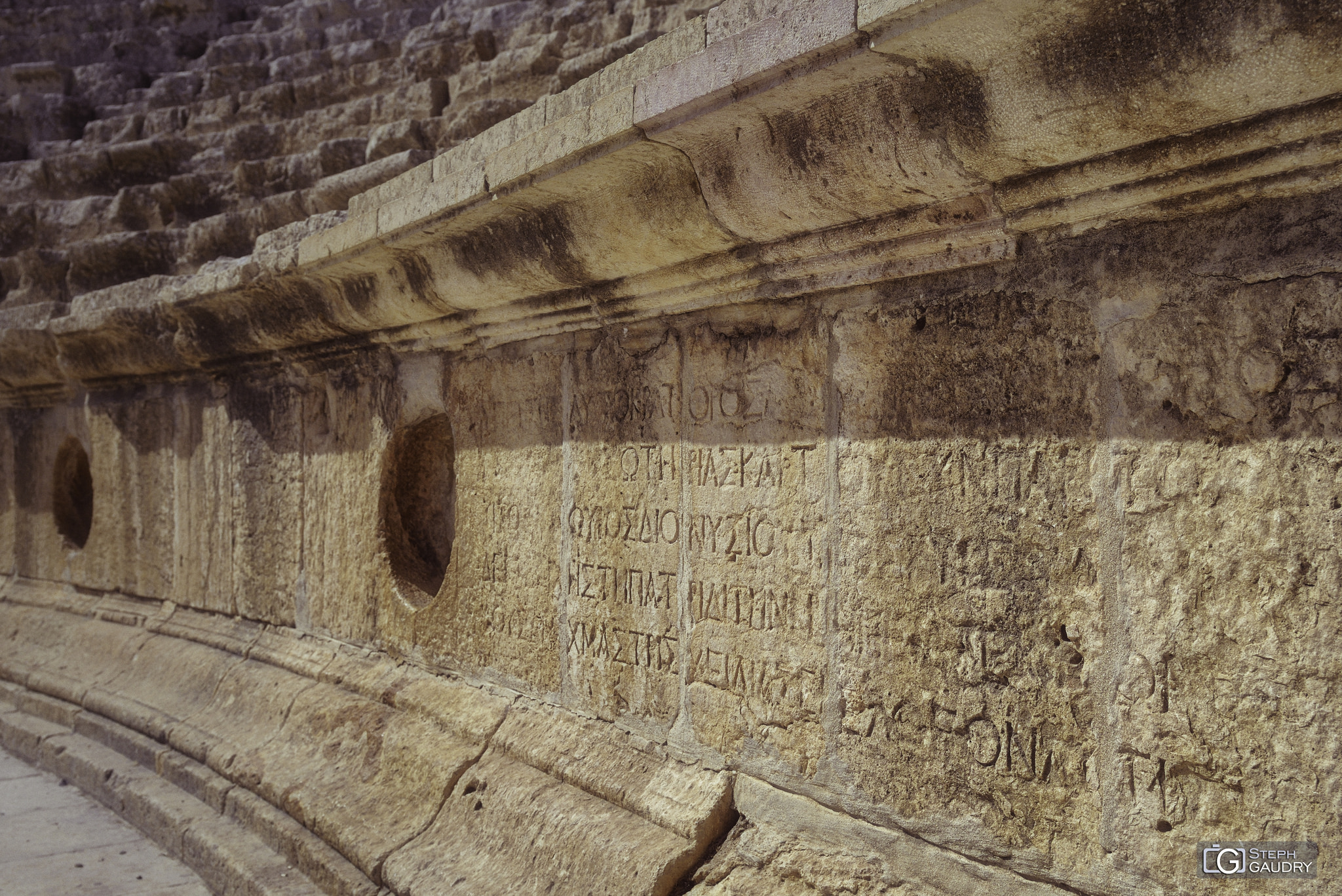 Détail d'écritures dans le théâtre Sud de Jerash [Cliquez pour lancer le diaporama]